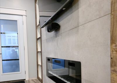 custom constructed fireplace feature wall with large tile and shelving units