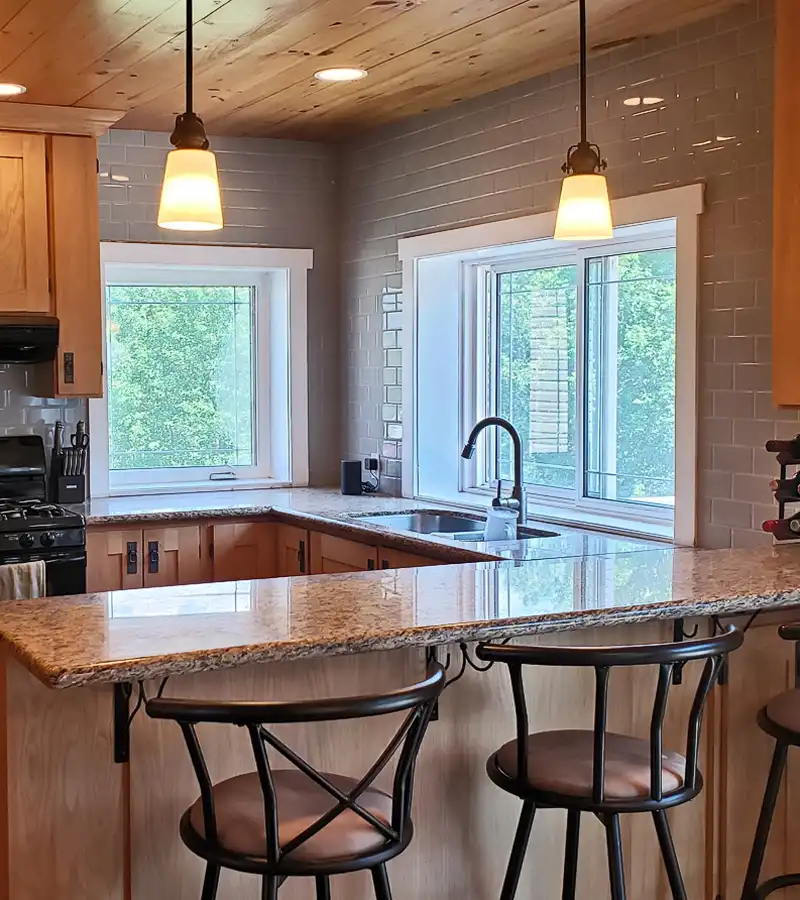 kitchen renovation with solid wood cabinetry, granite countertops, and grey subway tile